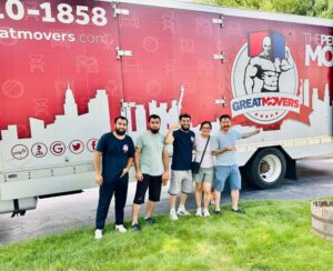 A smiling NJ Great Movers crew standing proudly in front of their red company moving truck, highlighting trusted, licensed movers in New Jersey.